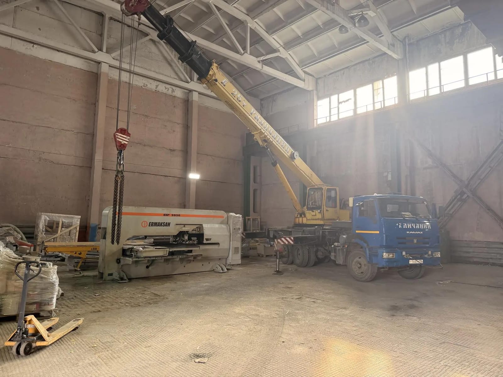 Автокран поднимает координатно-пробивной станок Ermaksan в производственном цехе